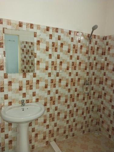 a bathroom with a sink and a shower at Keur Fall Aéroport in Saint-Louis