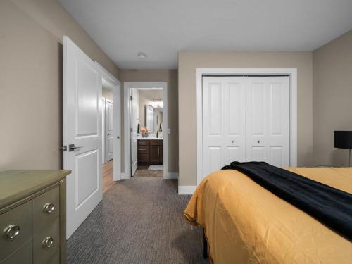 a bedroom with a bed and a bathroom at TC Parkside G: Spacious 2BR Condo in Traverse City
