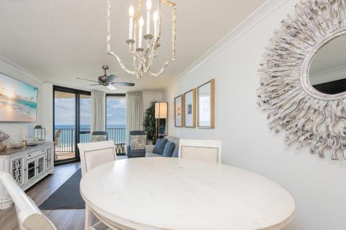a dining room with a white table and a large mirror at Phoenix VI 6906 in Orange Beach