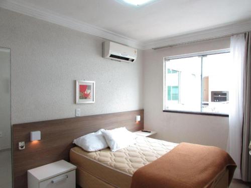 a bedroom with a bed with a large window at Bombinhas summer bech in Bombinhas