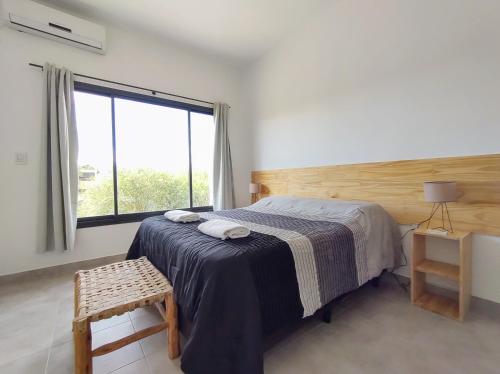 a bedroom with a bed and a large window at Algarrobos in Cafayate