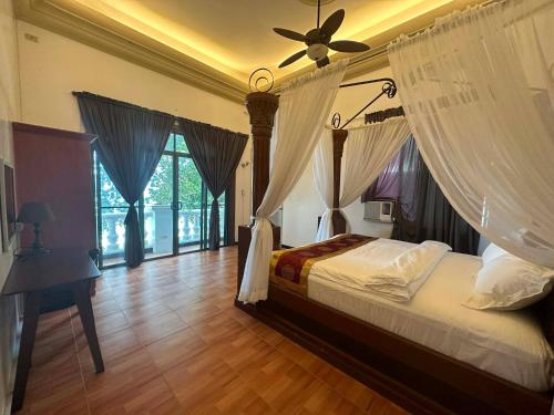 a bedroom with a bed with a ceiling fan at Gracey Dive Resort and Restaurant in Dauin