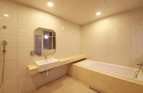 a bathroom with a sink and a bath tub at 아셈호텔 in Taech'on