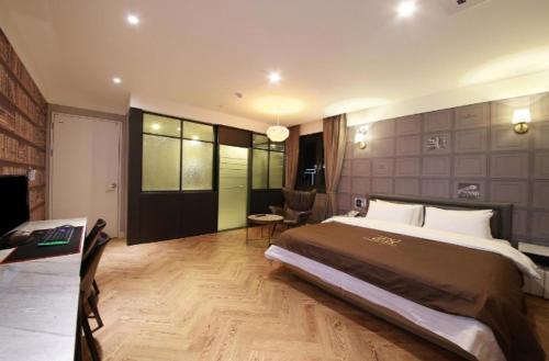a large bedroom with a large bed and a desk at 아셈호텔 in Taech'on