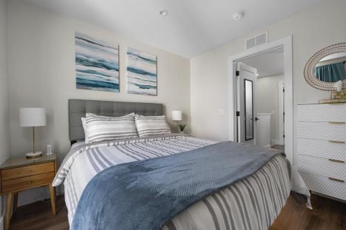 a bedroom with a large bed with a blue blanket at SkyBox|Rooftop|Downtown in Traverse City