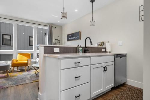 a kitchen with white cabinets and a sink at SkyBox|Rooftop|Downtown in Traverse City