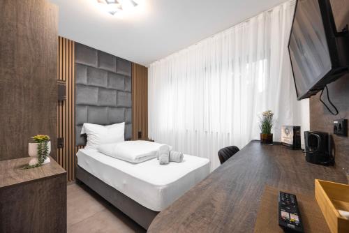 a bedroom with a bed and a desk and a television at Hotel Löwenstein in Lich
