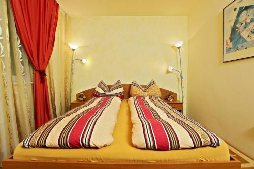 2 Betten mit gestreiften Kissen in einem Schlafzimmer in der Unterkunft Apartament Ema Baile Felix in Baile Felix