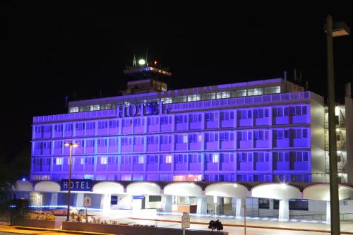 a building is lit up in purple at night at San Juan Airport Hotel in San Juan
