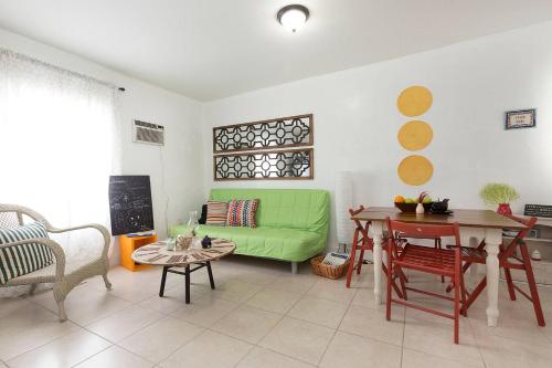 a living room with a green couch and a table at 1 Bedroom Apt near Coconut Grove in Miami