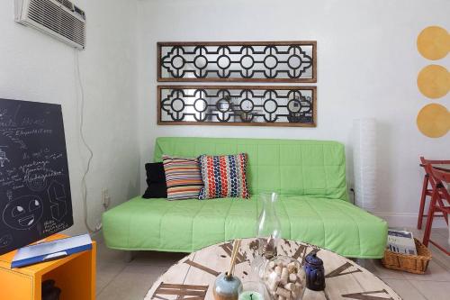 a green couch in a living room with a table at 1 Bedroom Apt near Coconut Grove in Miami