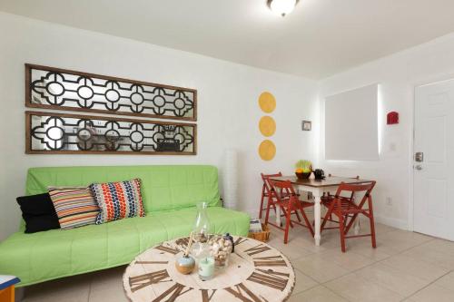 a living room with a green couch and a table at 1 Bedroom Apt near Coconut Grove in Miami