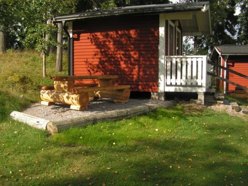 a bench sitting in front of a red building at Munkebergs Stugor & Vandrarhem in Filipstad