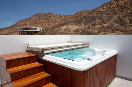 a hot tub on a balcony with a mountain at 2 BR Wake up to unique views from your balcony in Cabo San Lucas