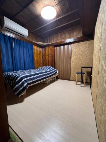 a bedroom with a bed in a room with blue curtains at ※Japanese Only【villa Ukishima】 in Naha