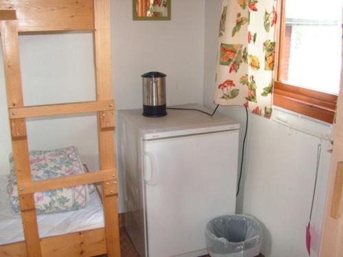 a small kitchen with a refrigerator and a ladder at Munkebergs Stugor & Vandrarhem in Filipstad