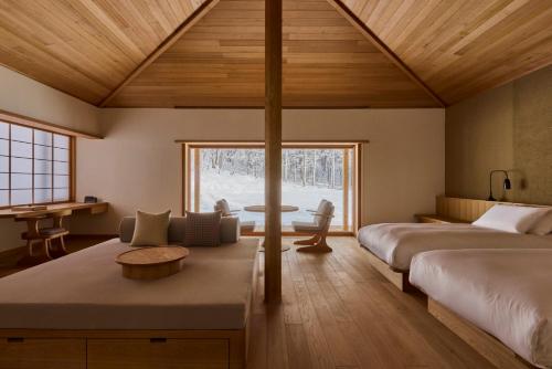 a bedroom with two beds and a desk and a table at AZUMA FARM Koiwai in Shizukuishi