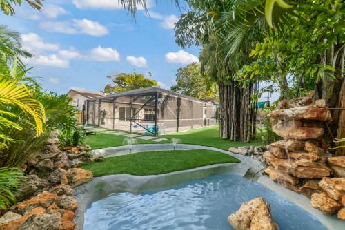 a garden with a koi pond and a house at Tropical Luxury Paradise - Fully Renovated in WPB in West Palm Beach