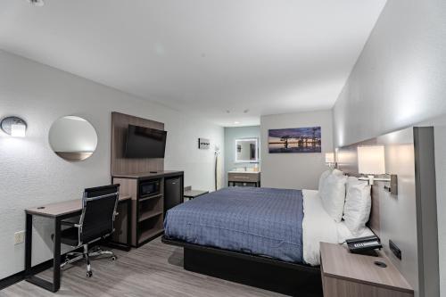 a hotel room with a bed and a desk at Executive Inn of Arlington, Near AT&T Stadium in Arlington