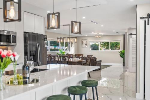 a kitchen with a bar with green stools at Tropical Luxury Paradise - Fully Renovated in WPB in West Palm Beach