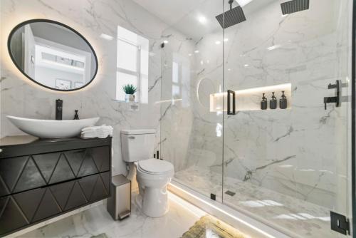 a bathroom with a shower and a toilet and a sink at Tropical Luxury Paradise - Fully Renovated in WPB in West Palm Beach