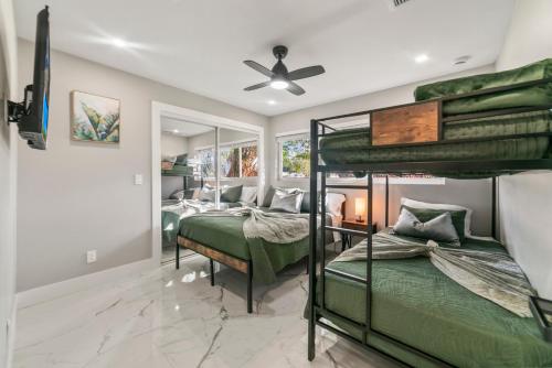 a bedroom with two bunk beds and a ceiling fan at Tropical Luxury Paradise - Fully Renovated in WPB in West Palm Beach