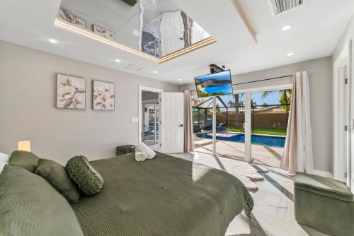 a master bedroom with a large bed and a flat screen tv at Tropical Luxury Paradise - Fully Renovated in WPB in West Palm Beach
