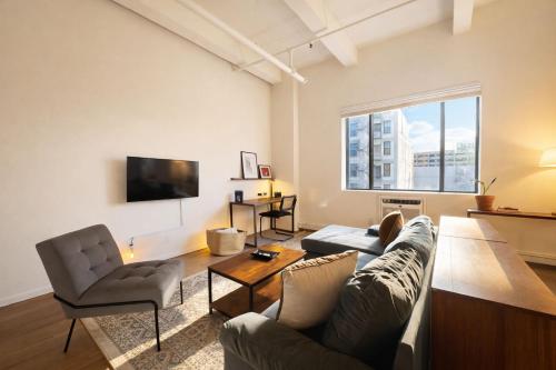 a living room with a couch and chairs and a tv at Westown Studio Apt Near Fiserv, Baird, and Theater District in Milwaukee