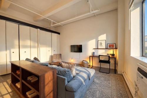 a living room with a couch and a tv at Westown Studio Apt Near Fiserv, Baird, and Theater District in Milwaukee