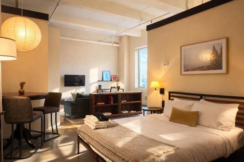 a bedroom with a bed and a living room at Westown Studio Apt Near Fiserv, Baird, and Theater District in Milwaukee