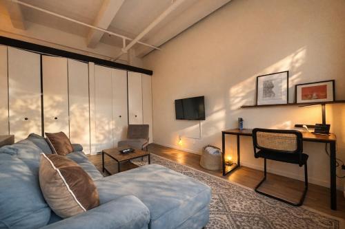 a living room with a blue couch and a television at Westown Studio Apt Near Fiserv, Baird, and Theater District in Milwaukee