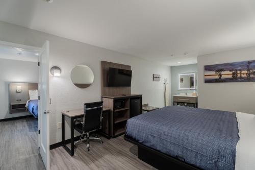 a hotel room with a bed and a desk and a computer at Executive Inn of Arlington, Near AT&T Stadium in Arlington