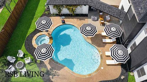 an overhead view of a swimming pool with umbrellas at Elegant 5BR Pool House with Cinema Fire Pit and Games in Keller