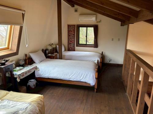 a bedroom with two beds and a window at Atami Ocean & Star Cottage in Atami