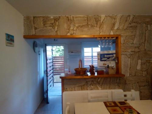 a kitchen with a stone wall and a table and chairs at Departamento duplex Pinamar in Pinamar