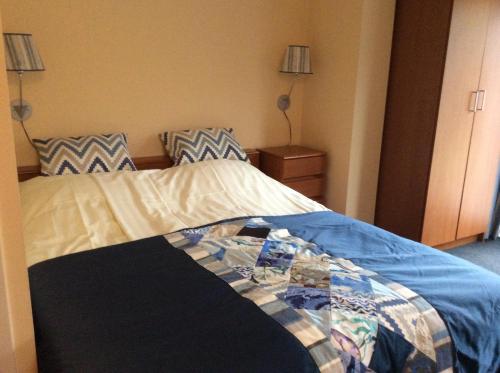 a bedroom with a bed with a blanket on it at Appartementen de Strandloper in Bergen aan Zee