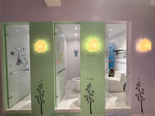 a bathroom with a shower and a toilet and two lights at G.S. Holiday Home in Guanshan