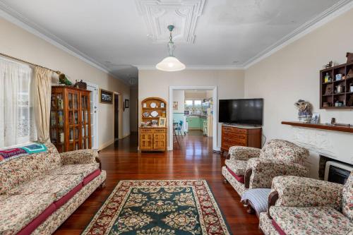 a living room with two couches and a television at Albert Road Cottage, Bunbury - 3 bedroom & caravan in Bunbury