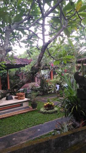 a garden with flowers and plants in a building at Suryadina Guest House in Ubud