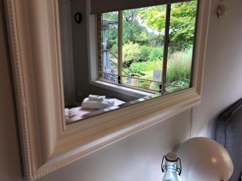 a mirror on a wall with a reflection of a window at Rocky Rest in Orange