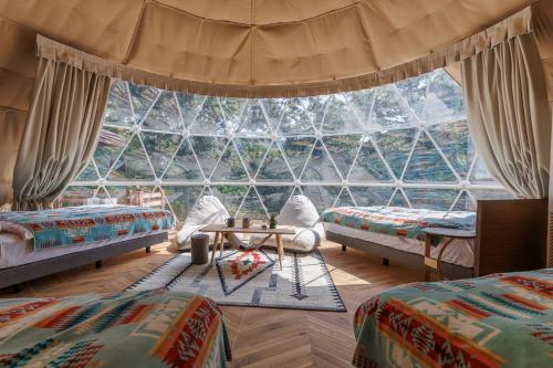 a room with two beds and a large window at Morethan Paradise in Nagatoro