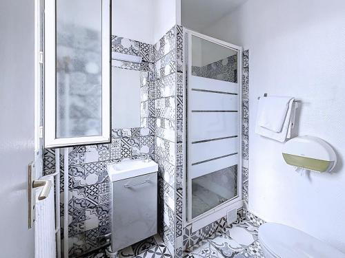 a bathroom with a toilet and a mirror at HOTEL WATTIGNIES in Paris