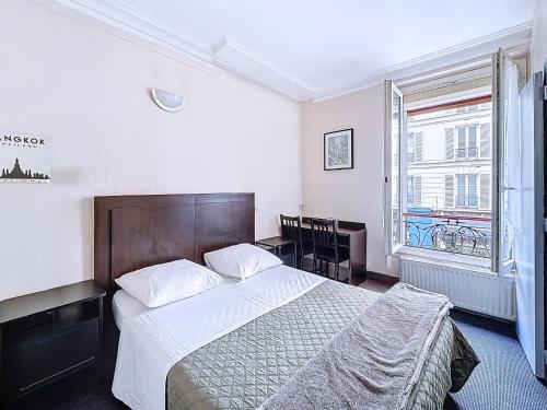 a bedroom with a large bed and a window at HOTEL WATTIGNIES in Paris