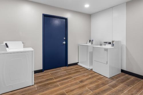 a room with white walls and a blue door at Spark by Hilton Salt Lake City Central in Salt Lake City