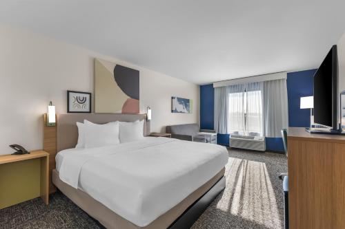 a hotel room with a large bed and a television at Spark by Hilton Salt Lake City Central in Salt Lake City