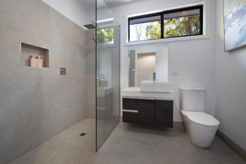 a bathroom with a toilet and a sink and a window at Ablac House in Glenlyon
