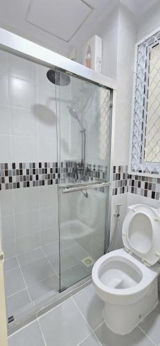 a bathroom with a shower and a toilet at Nala Host - 2BR Garden Home in Hulhumale