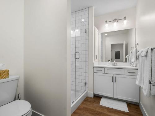 a white bathroom with a toilet and a sink at Cozy Capri Condo: Charming 1BR 1BA Downtown! in Traverse City