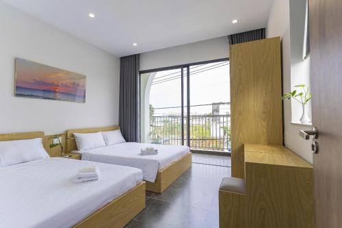 a hotel room with two beds and a window at Tidal Mist Homestay in Long Hai