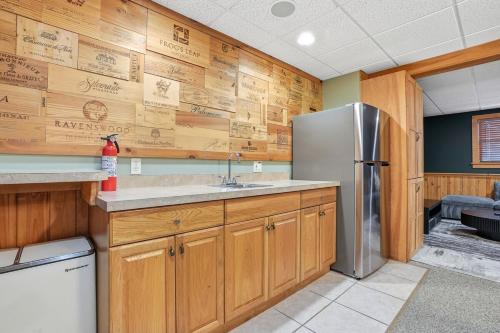 a kitchen with wooden walls and a stainless steel refrigerator at Luxury Poconos Chalet - 3 Mins to Camelback in Tannersville